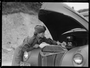 Female soldier cleaning a 1938 Ford military car