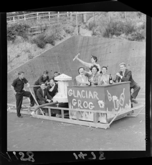 Unidentified students in a makeshift sledge with 'glaciar grog' written on it, in preparation for the Victoria university capping procession, Wellington