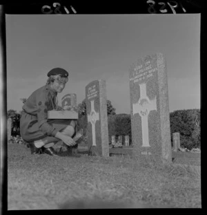 A girl guide laying a posy at a serviceman's grave, war cemetery, Wellington