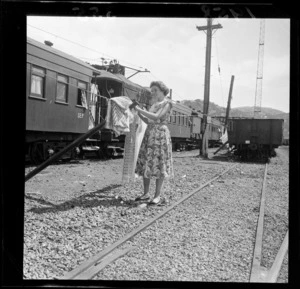 Circus worker standing at the clothesline alongside the railway carriage accommodation