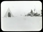 [Man with sled full of supplies next to a tent]