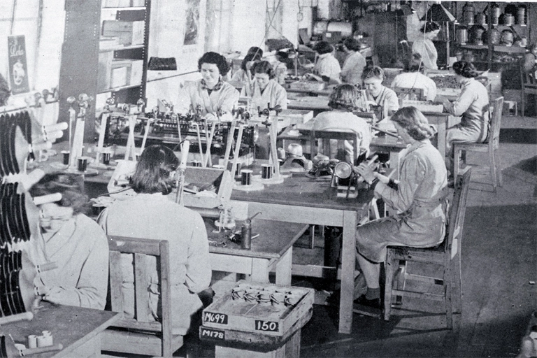 Girls in a small workroom engaged on assembly work