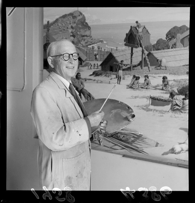 Artist Marcus King standing with a palette in front of his painting
