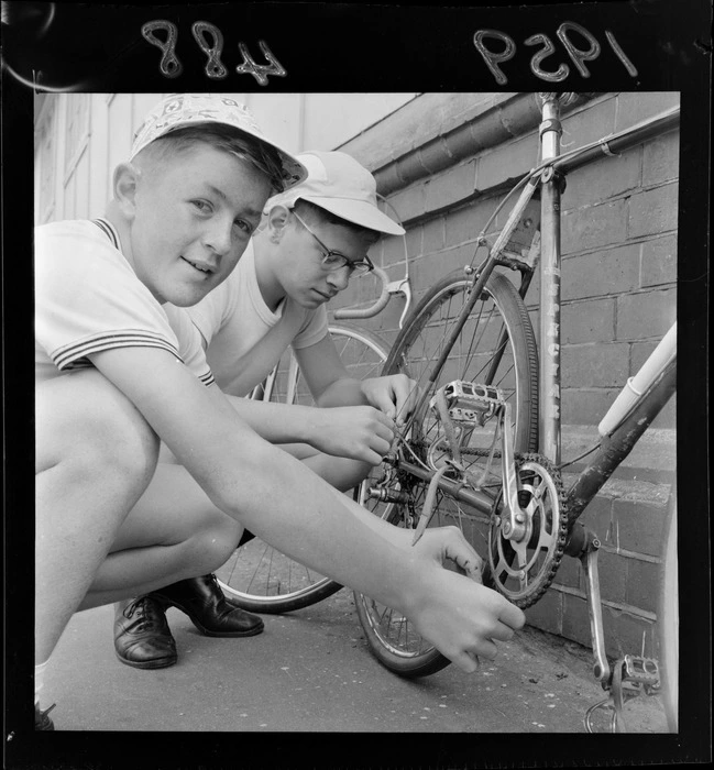 Two unidentified boys fixing the chain on a bicycle after taking part in a schoolboy's cycle race