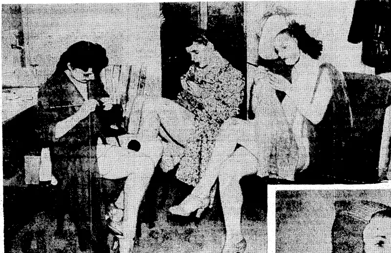 Knitting comforts for the soldiers is practised in. all sorts of places in England, and few women have idle moments. Above, girls in the non-stop revue at the Prince of Wales Theatre, London, utilise their spare moments by knitting scarves, balaclavas, or socks. Right, a girl member of the Women's Auxiliary Territorial Service trying oh a balaclava which, has been made out of ladies1 silk stockings by a method of interweaving. (Evening Post, 02 March 1940)