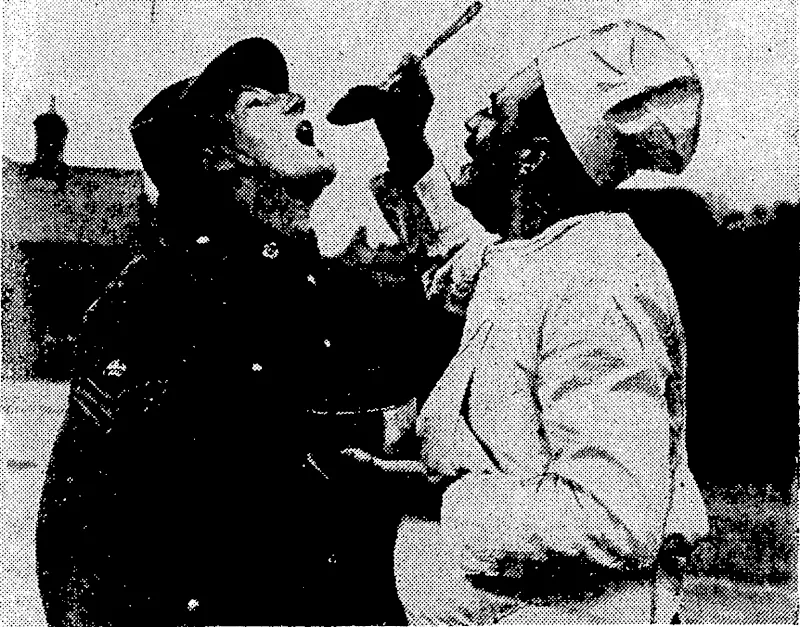 Sport and General" Photo. A Canadian army cook from Peterborough, Ontario, whose name is Cooke, giving a taste* of Christmas pudding to Staff-Sergeant-Major Hollis, of the New Zealand Army Service Corps. , (Evening Post, 25 January 1941)