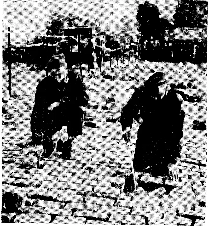 Canadian soldiers searching for mines in a Dutch town. (Evening Post, 18 October 1944)