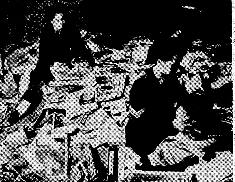 Sorting periodicals collected by the postmen and others on Saturday* These books and periodicals were taken to the headquarters of the Country Library Service, where they are being packed to be sent to (Evening Post, 08 May 1945)
