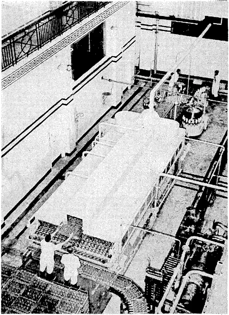 Evening Post" Pfcoto. This machine, recently installed at the Wellington Municipal. Milk Depot, cleans and fills the bottles in one operation. The empty, bottles enter the machine at the end nearest the camera and issue from the other end filled and topped ready for'crating and delivery. (Evening Post, 12 July 1939)