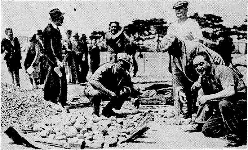 Evening Post" Photo. Cooking-pork and potatoes in the Maori fashion at the Petone Recreation Ground yesterday, one of the items of "Maori Day" in connection with the Petone jubilee celebrations. (Evening Post, 30 November 1939)