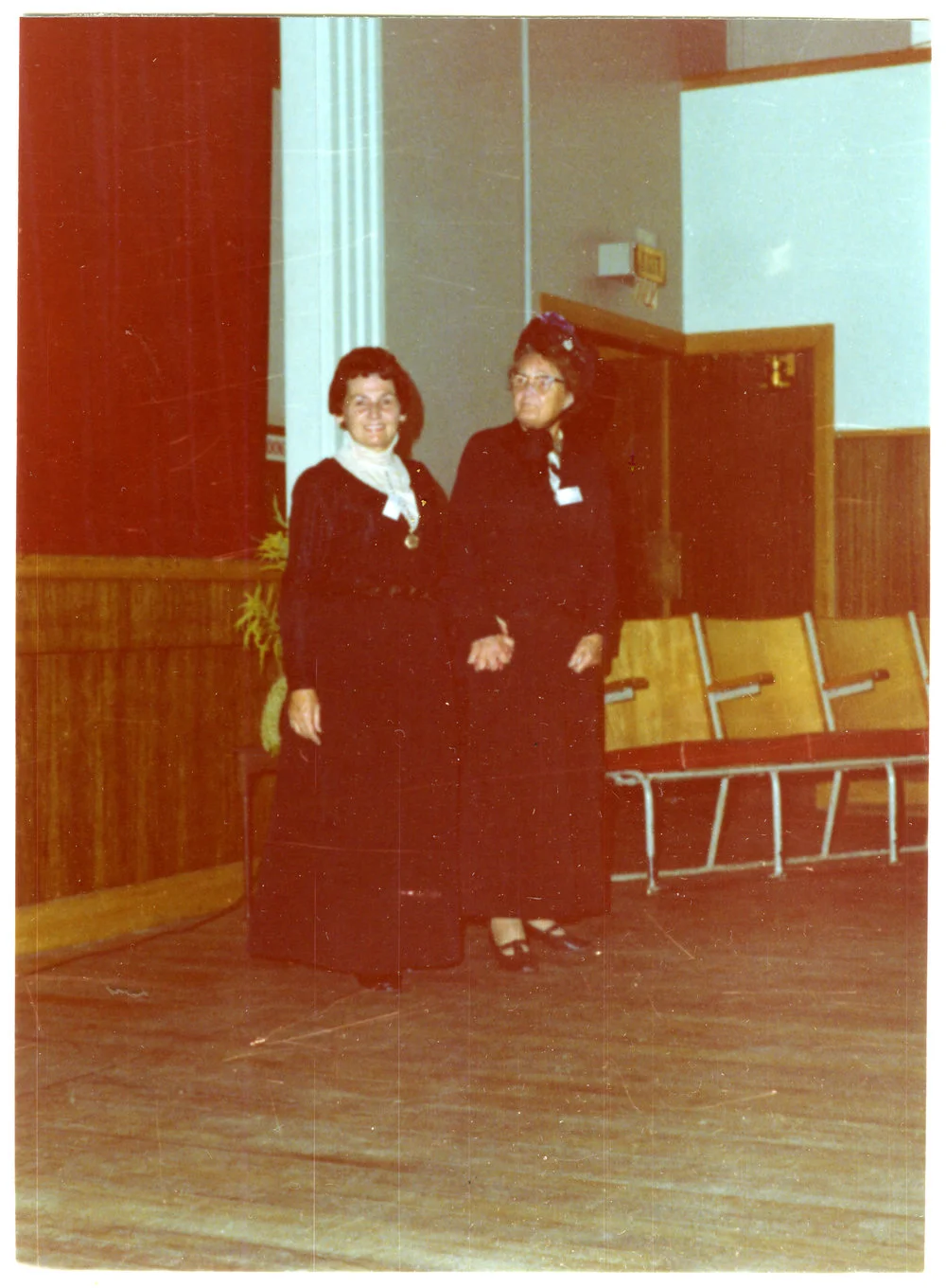 Two women stand in a sports gymnasium wearing period clothing, Cromwell Church