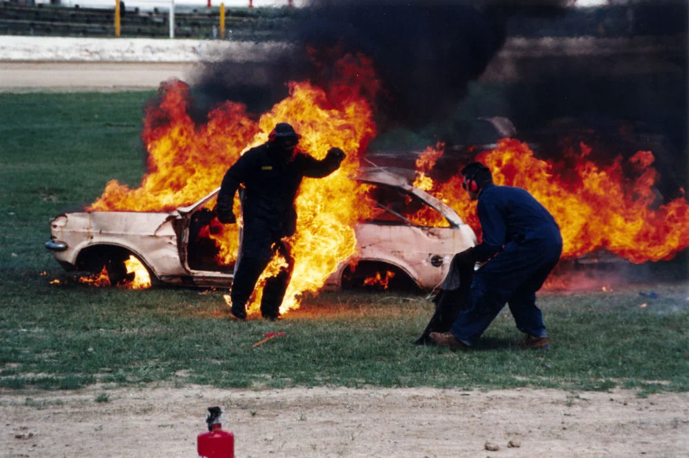 Te Marua speedway; Rob Cochrane douses flames on stuntman "Dwane".