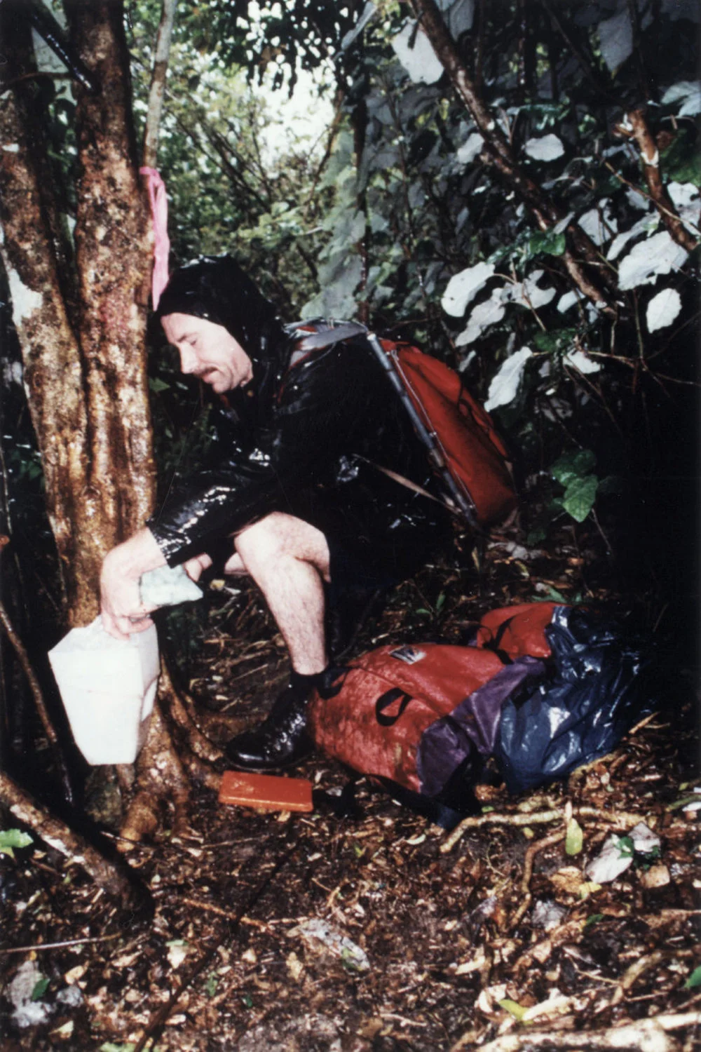 Possum control; Mark Rossiter, Forest and Bird Society, fills a 1080 bait station.