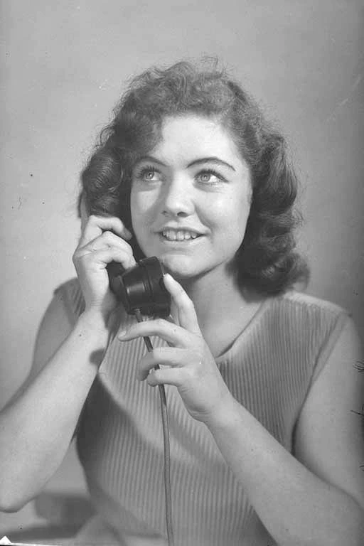 Head and shoulders portrait of Miss Leonie Hawkins, using the telephone