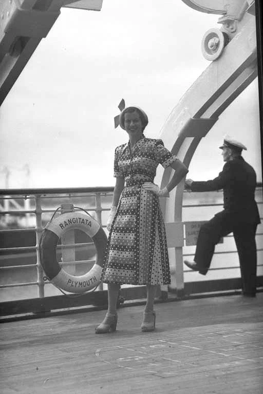 Full length portrait of model Ann Thomas modelling a dress for Reslau Frocks on board the 'Rangitata'