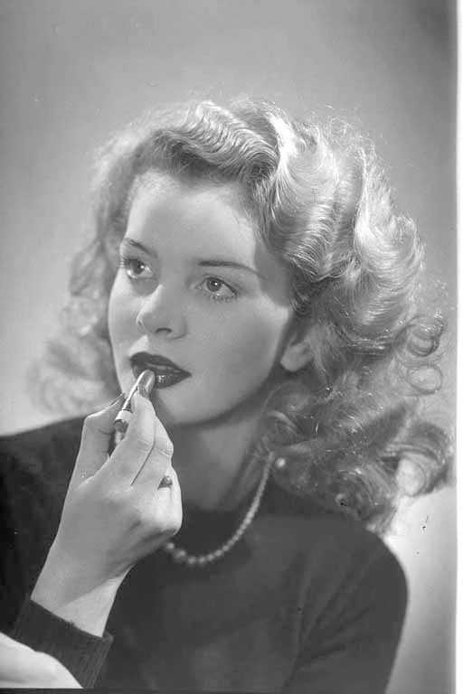 Head and shoulders portrait of a model using lipstick for Wardlaw Advertising