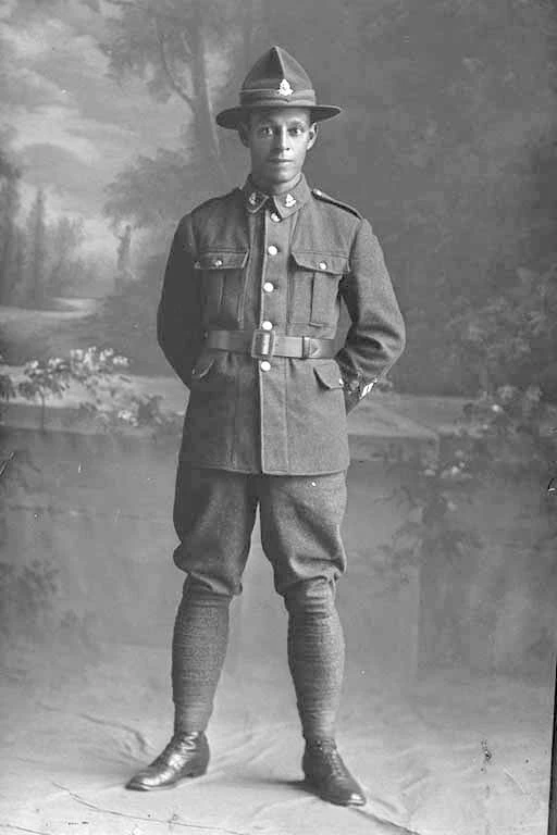 Full portrait of Private George Spencer Hyatt, Reg no. 52046, Specialists Company - Signal Section, 29th Reinforcements, wearing crossed flags patch signifying Assistant Instructor in Signalling