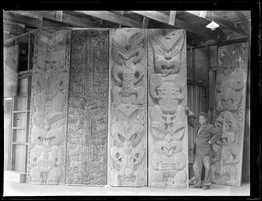 Maori carvings, Rotorua - man standing by carving