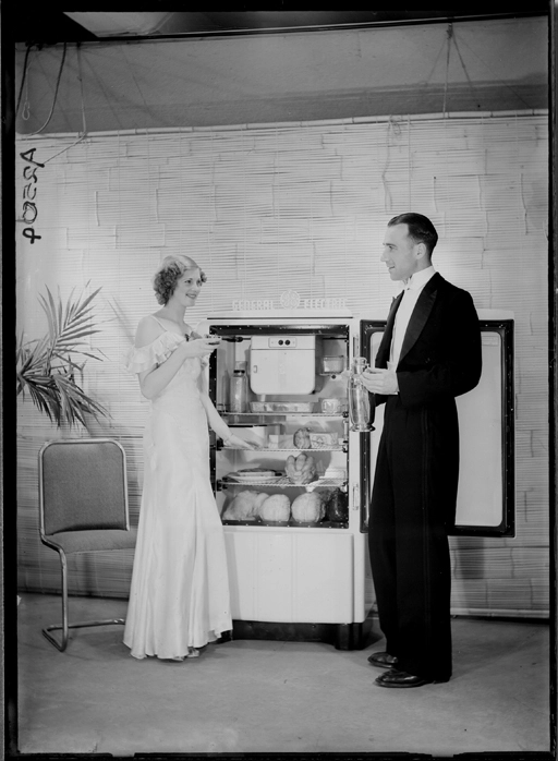 Showing models standing by a General Electric refrigerator for Neeco Wholesalers Limited 1940