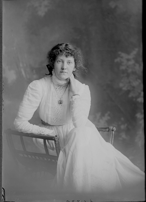 3/4 length portrait of Miss Moran, sitting in a wooden chair,....