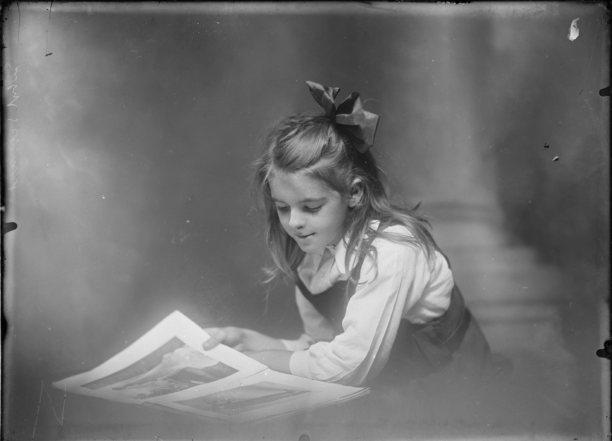 Young girl looking at a book of photographs