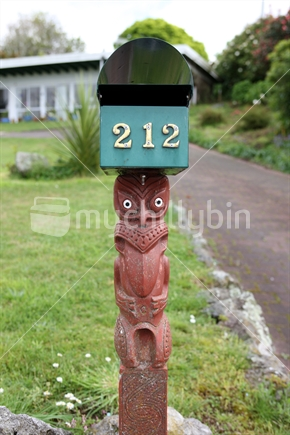 A Maori carved pole holds up a letterbox in Rotorua, New Zealand