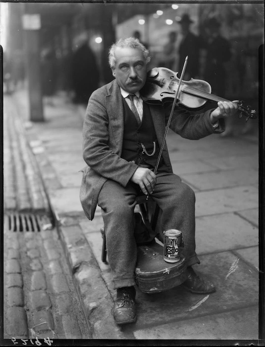 Unidentified man on street, playing violin