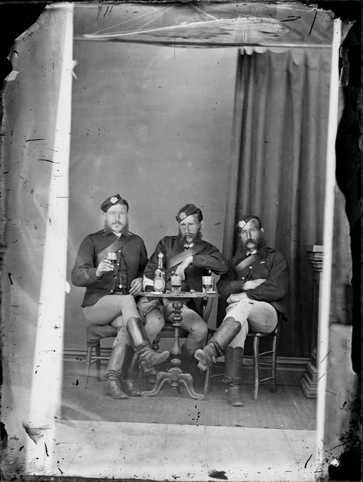 Unidentified men seated in army uniform drinking ale