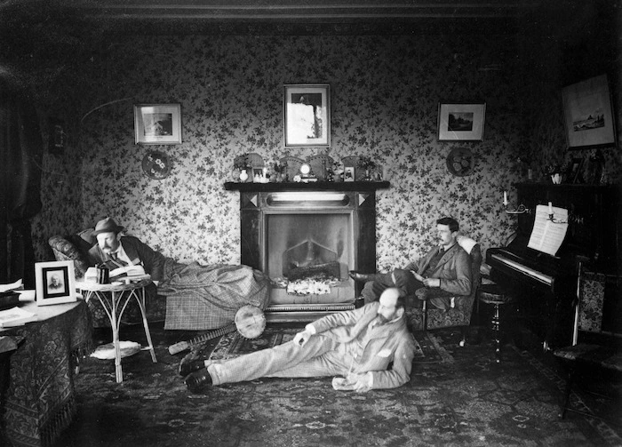 Three men around a fire in a living room