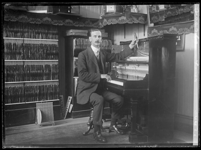 Music shop, with man tuning a piano, and sound recordings