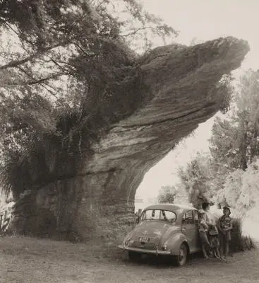 (Outcrop of rock over family and car)