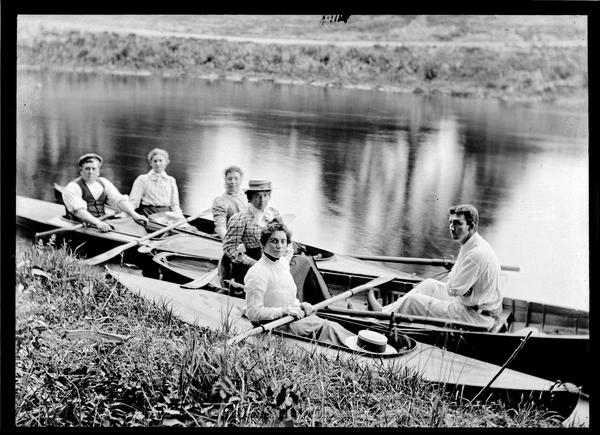 Two men and four women in canoes and rowboats