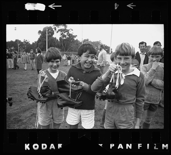 Children holding rugby boots