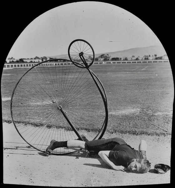 Fred Wood lying on the ground with a penny-farthing