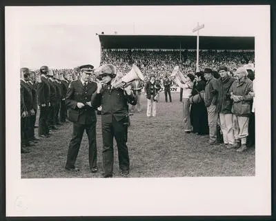 [A police line and protesters face off on the rugby pitch at Rugby Park, Hamilton]