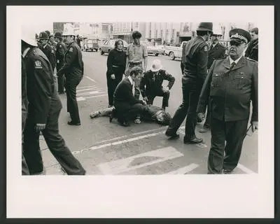 A demonstrator lies bloody unconscious in Victoria St, Hamilton.