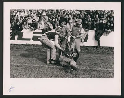 Rugby supporters hand a demonstrator off the Field, Hamilton.