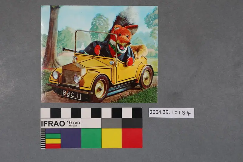 Postcard: Basil Brush puppet in a yellow car