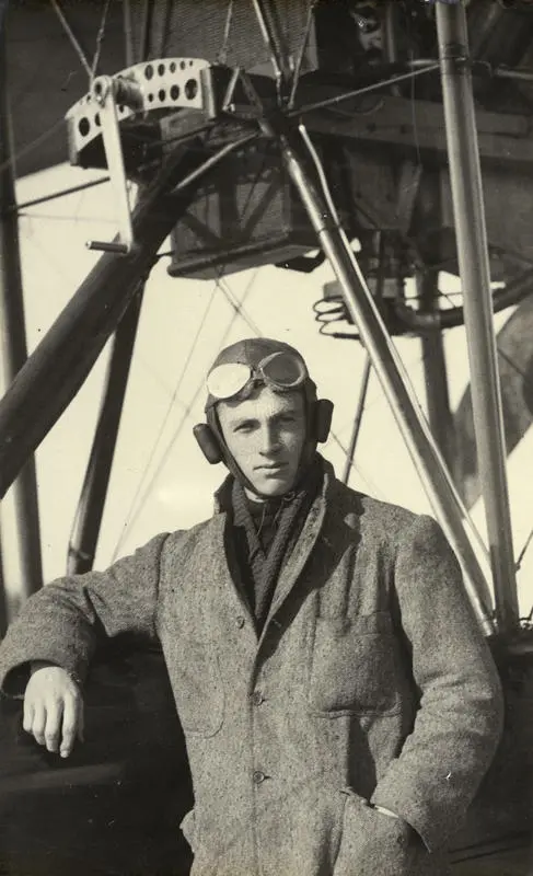 Black and white photograph of A. H. Murison, graduate of the Walsh Brothers Flying School, wearing pilot's clothing standing by a Walsh Flying Boat "D"