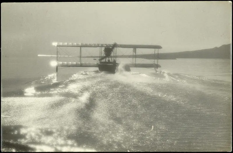 Black and white photograph of Curtiss "C" seaplane of the Walsh Brothers Flying School taking off