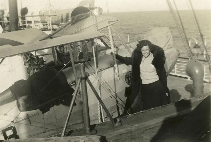 Jean Batten in front of Gipsy Moth G-AARB on deck of Union Steam Ship's (USS) Aorangi