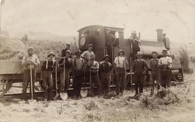 Workmen alongside engine