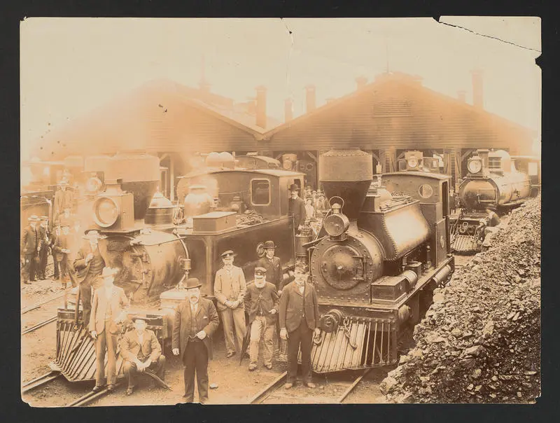 Steam locomotive and staff at rail yard