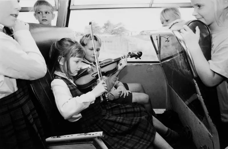 Entertaining Her Friends On The School Bus, Seven-Year-Old Julia Lissington Practises Her Violin On The Way Home
