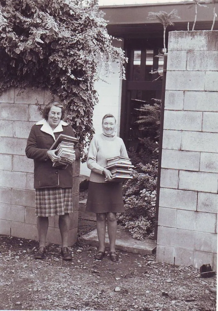 Pam Lyon and Elaine Morse carrying new stock into library, mid 1970's