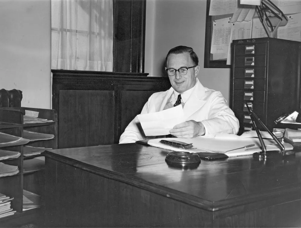 Sir John Walsh at his desk, Dean's Office, Dental School, University of Otago