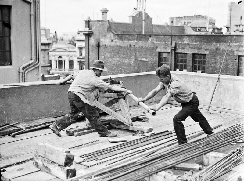 Central City. Building Construction on Beaths Site. Bending reinforcing rods. The Back of the DIC sign facing Cashel Street can be seen Centre Top. Christchurch, Canterbury, New Zealand.