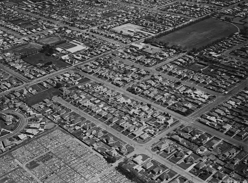 Aerial. Oblique. Sydenham Cemetery at Bottom Left Barrington Street across the top with Barrington Park at Top Right and the light coloured Vogue Picture Theatre in the centre. This was the Nucleus of the Later Barrington Shopping Centre. Sydenham, Christchurch, Canterbury, New Zealand.