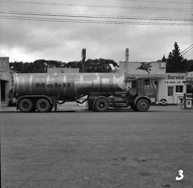 Motor Vehicle, Truck. AEC Mobil Road Tanker. Outside A B Main Ltd Service Station, Note Kerbside Petrol Bowsers ( Pumps ). An Open 7 Days Sign. Kurow, Otago, New Zealand.