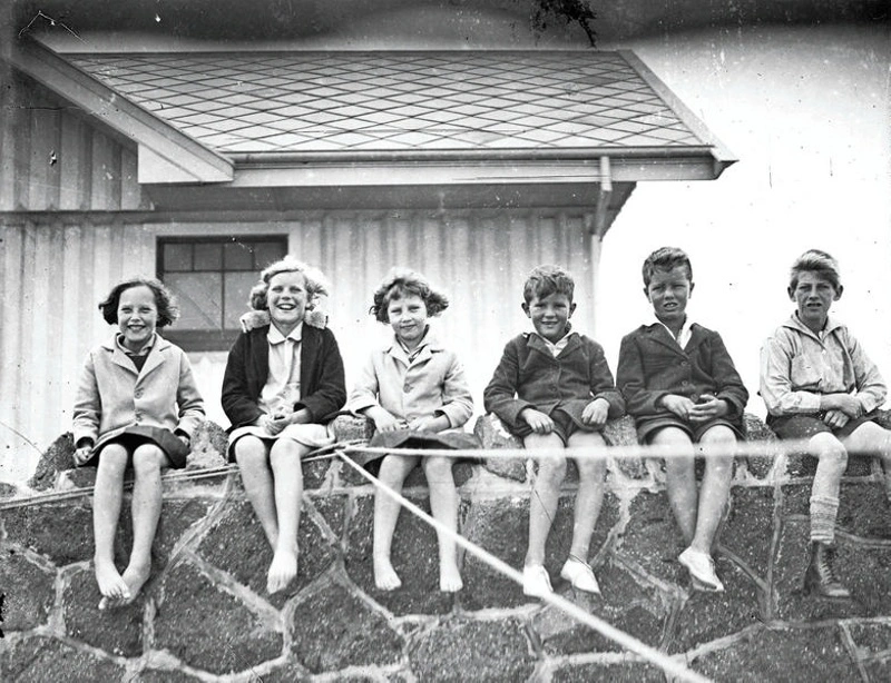 Children Sitting on Stone Wall. Christchurch, Canterbury, New Zealand.